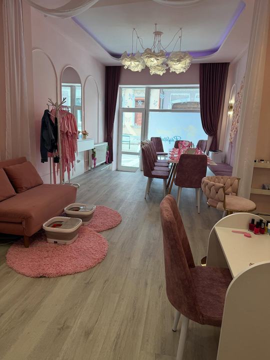 Salonul văzut de la intrare: canapeaua de spa, măsuțele și halatele
